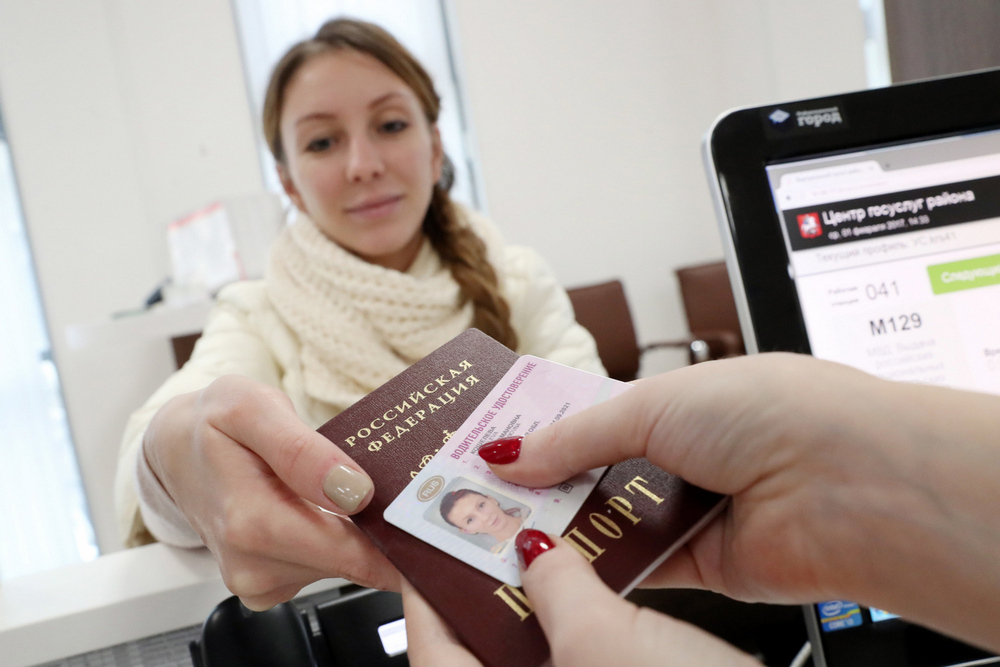 Девушка с водительским удостоверением и паспортом в руках